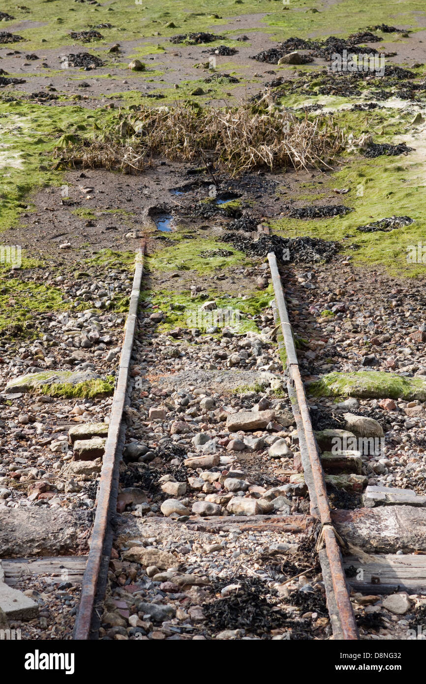 Una barca in disuso scivolo che conduce al porto di Chichester Foto Stock