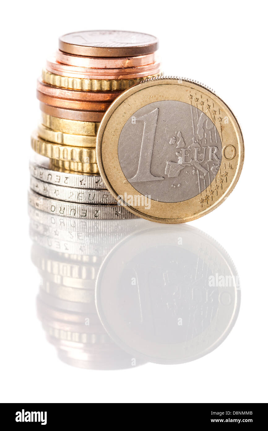 Una standing 1 monete euro - moneta di Unione europea - appoggiata sulla pila di euro e centesimi di euro su bianco superficie riflettente Foto Stock