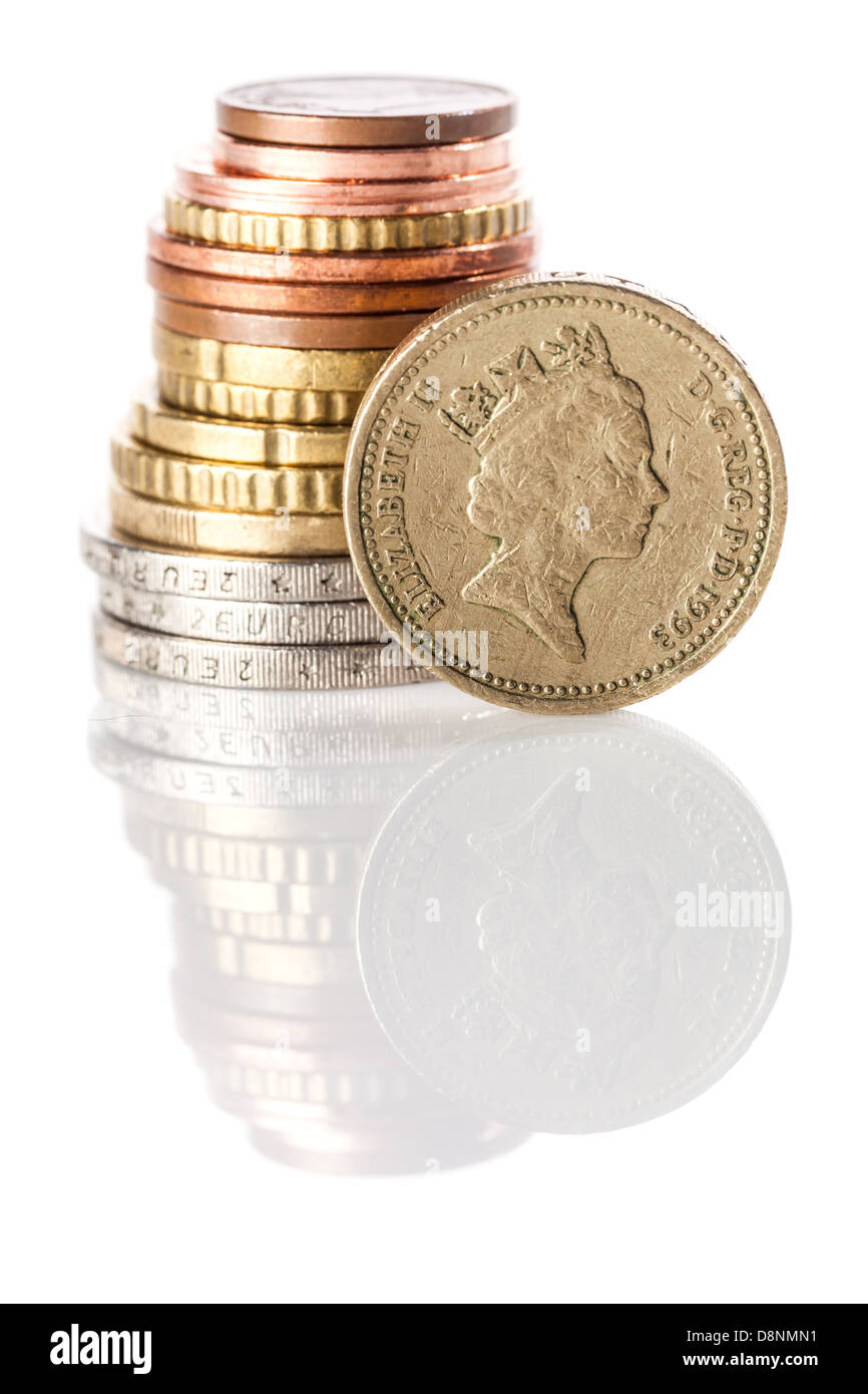British pound coin sulla pila di euro e centesimi di euro su bianco superficie riflettente Foto Stock