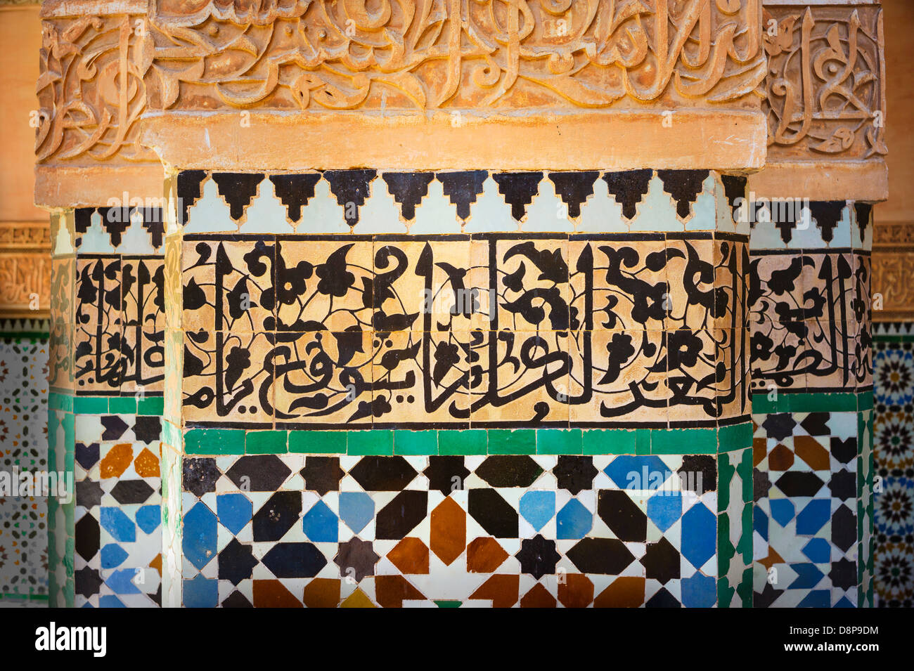 Dettaglio del vivid blue, nero, rosso e piastrelle bianche e pietra intagliata, di color ocra calligraphy in moschea, Marrakech, Marocco Foto Stock