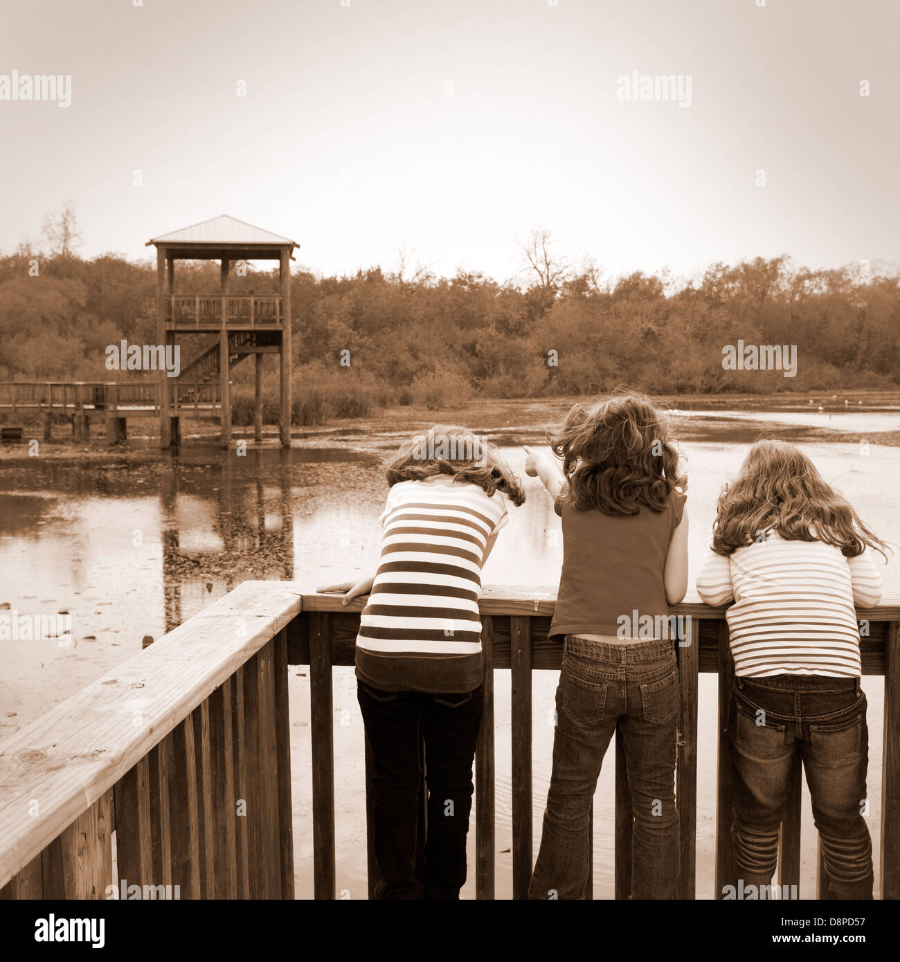 Kid bambini ragazze cercando e puntando al parco lago in Texas vista posteriore Foto Stock