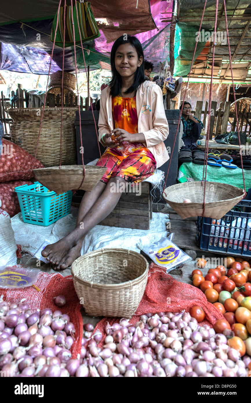 Giovane ragazza birmano vendita di cipolle e pomodori al cibo locale street market Mandalay MYANMAR Birmania Foto Stock