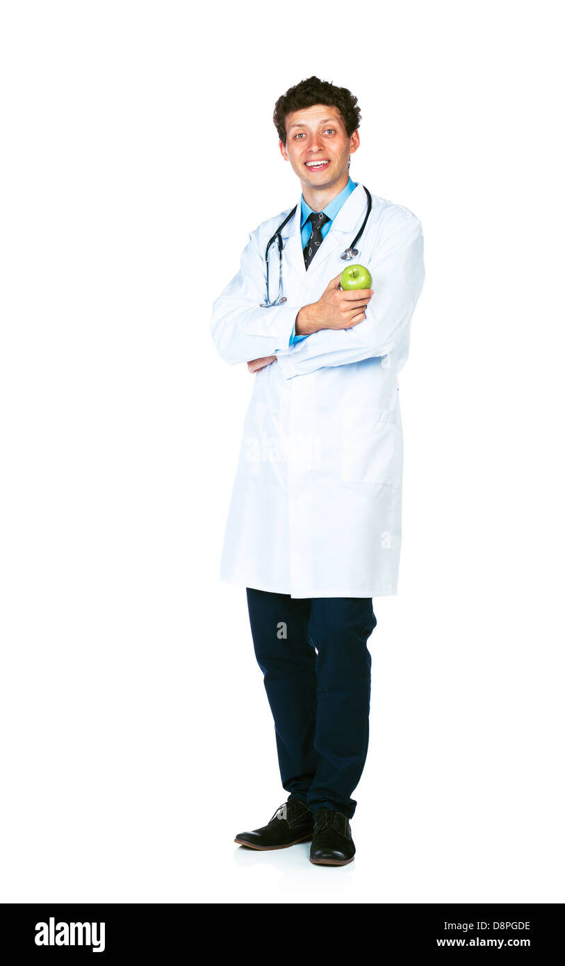 A piena lunghezza Ritratto di un maschio sorridente medico tenendo premuto mela verde su sfondo bianco Foto Stock