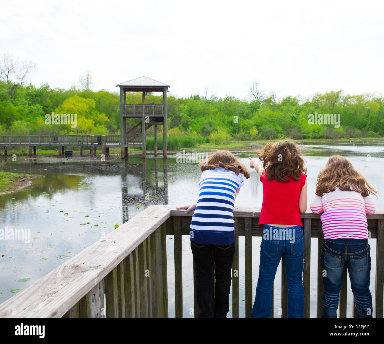 Kid bambini ragazze cercando e puntando al parco lago in Texas vista posteriore Foto Stock