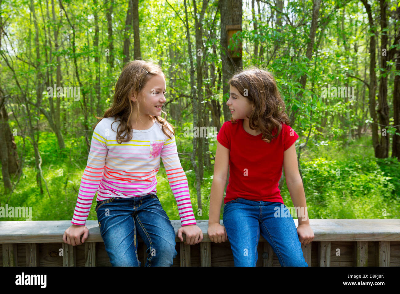 Bambini suor amici parlando rilassante seduta sulla giungla foresta del parco all'aperto Foto Stock