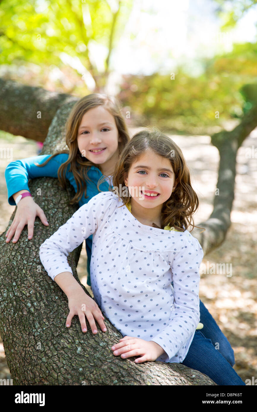 Amici sorella ragazze in appoggio sul tronco di albero natura outdoor Foto Stock