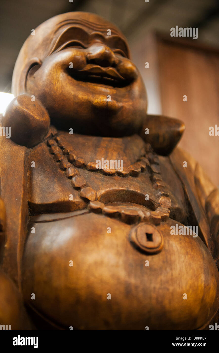 Un di legno statua del Buddha con grande pancia Foto Stock