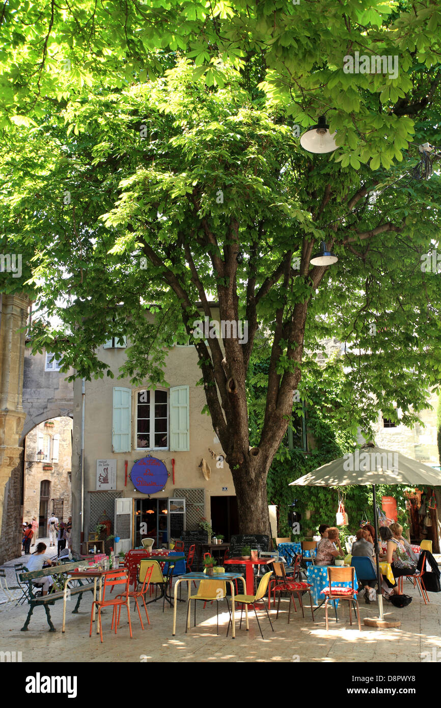 Le persone aventi le bevande all'ombra di un platano centenario in Saint Remy de Provence. Foto Stock