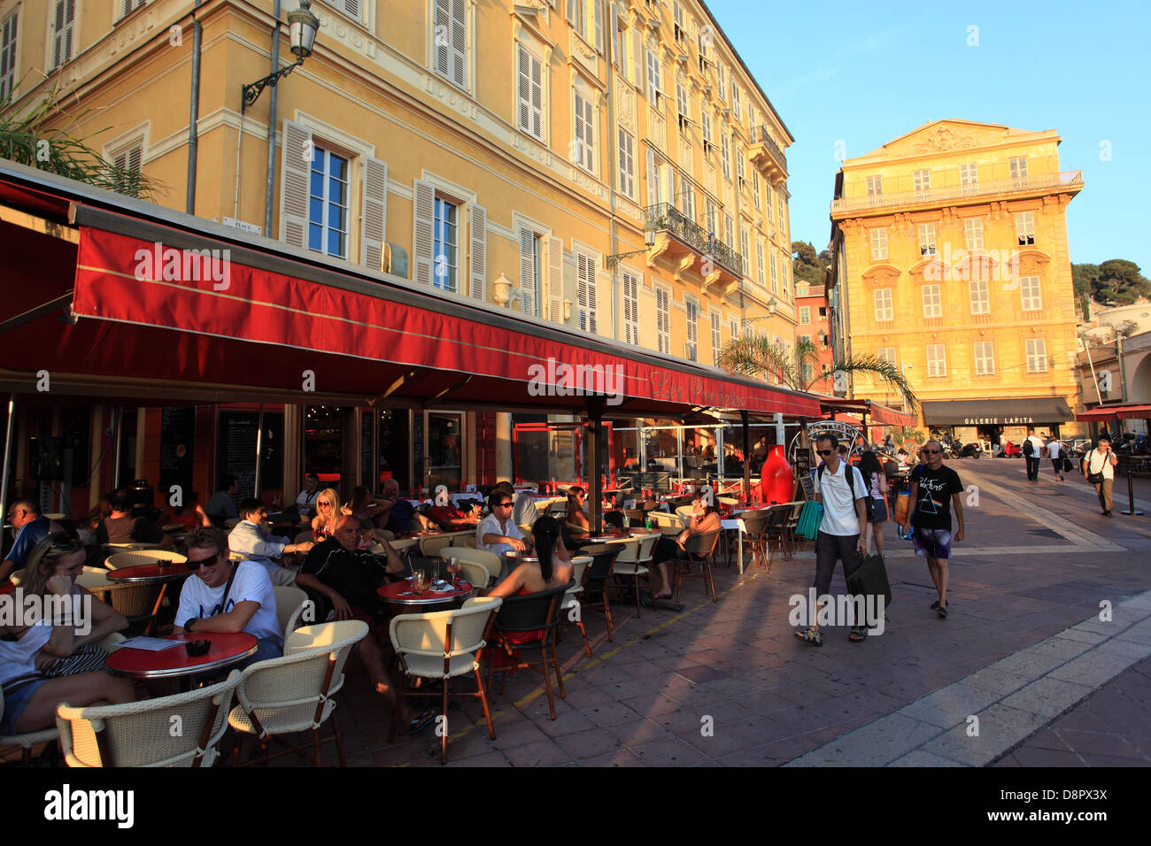 Le persone aventi le bevande al di fuori in Cours Saleya nel centro storico della città di Nizza Foto Stock