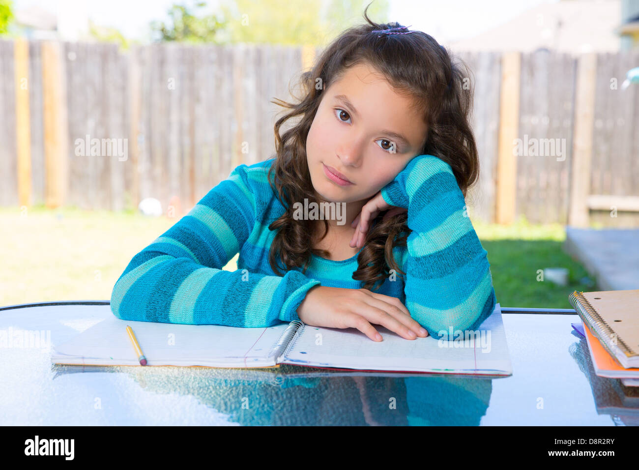 Latino Americana teen ragazza rilassato sulla tabella facendo i compiti sul cortile Foto Stock