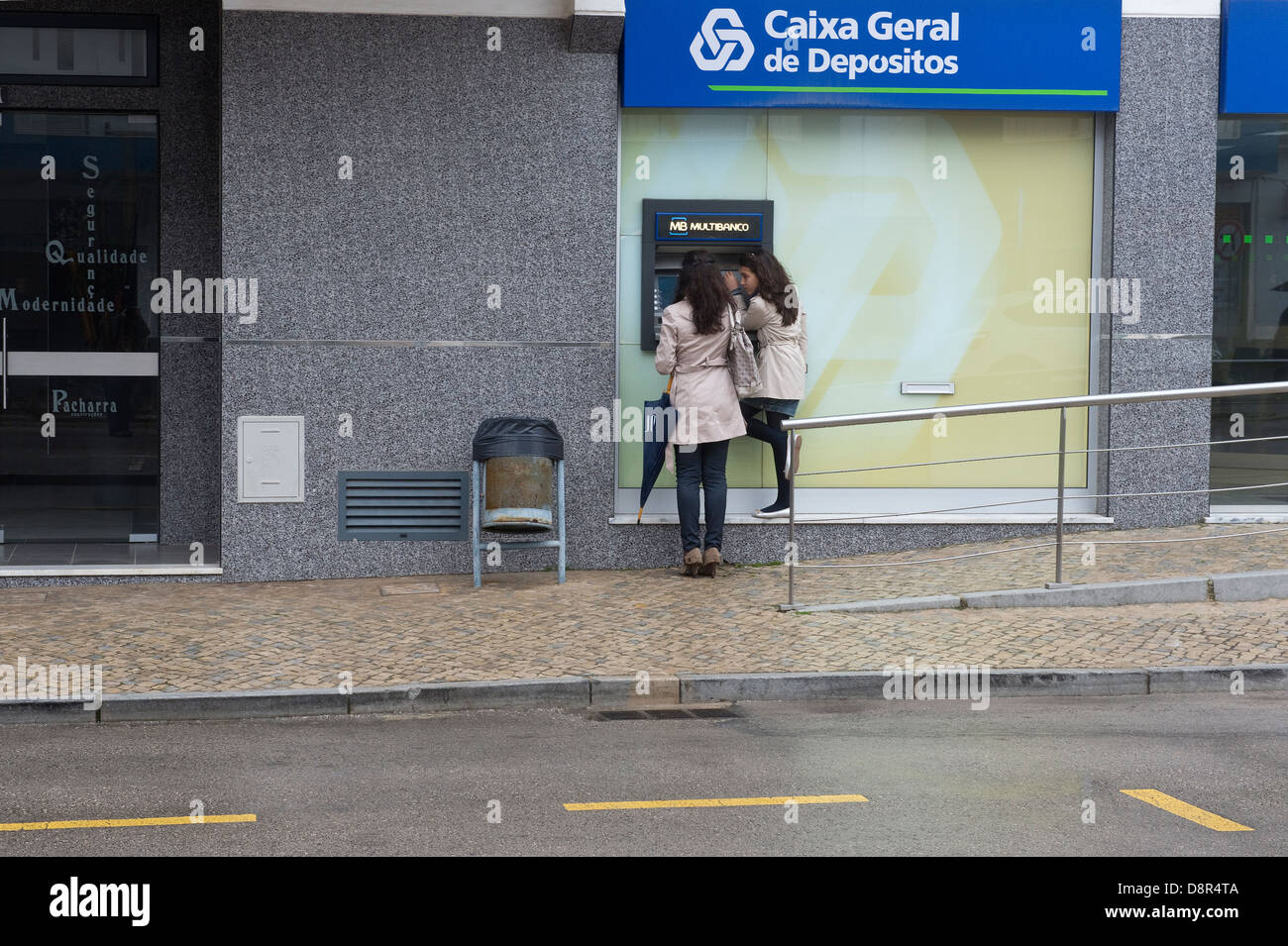 Due giovani donna presso la Caixa Geral de Depositos cash macchina distributrice di São Brás de Alportel Algarve Portogallo Europa Foto Stock