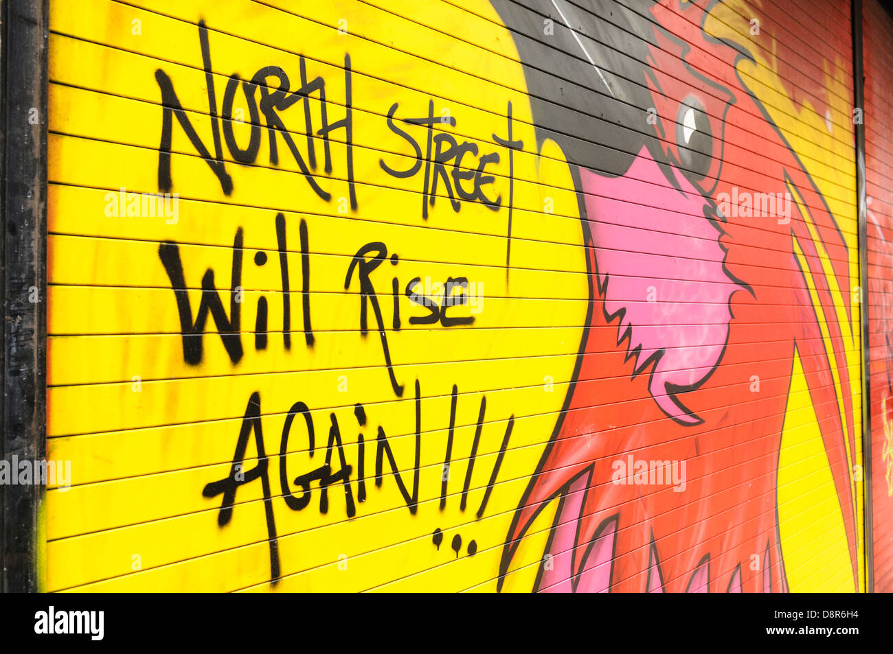 Grafitti su un negozio otturatore "North Street aumenterà ancora' con una phoenix dopo il North Street arcade a Belfast è stato distrutto Foto Stock