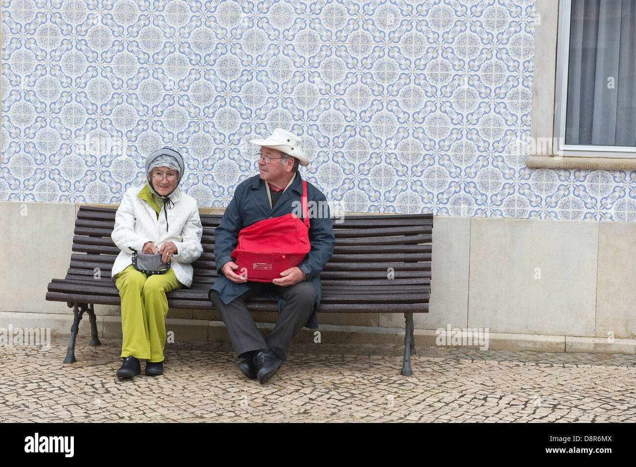 Coppia di anziani in appoggio sul banco dopo la Domenica di Pasqua Fiore Festival torce São Brás de Alportel Algarve Portogallo Europa Foto Stock