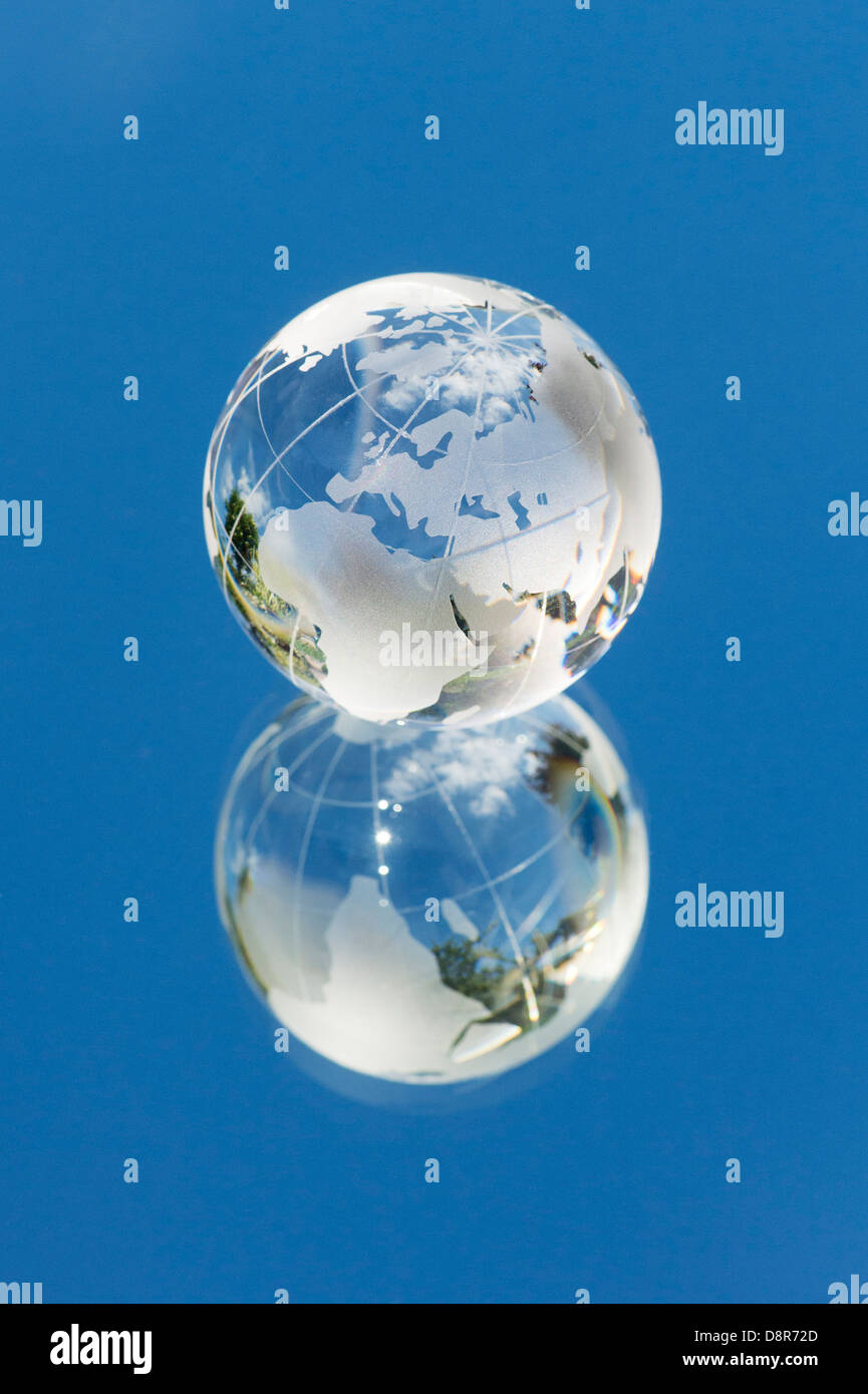 Crystal globo di vetro / Massa / mondo su uno specchio che riflette il cielo blu Foto Stock