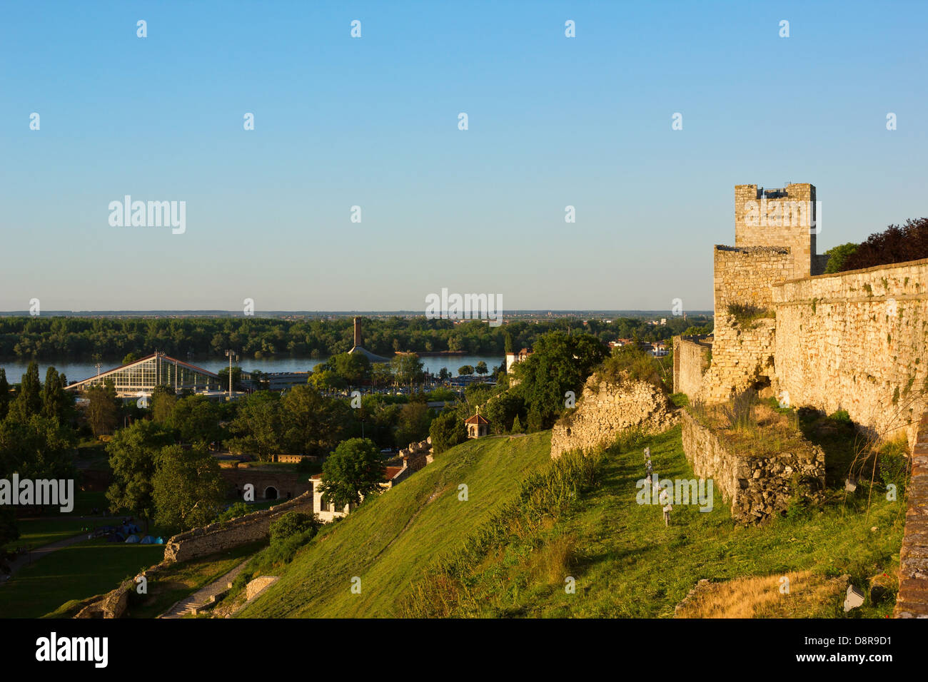 Belgrado vista panoramica verso il fiume Danubio dal Parco Kalemegdan con mura illuminate dal sole al tramonto. Foto Stock