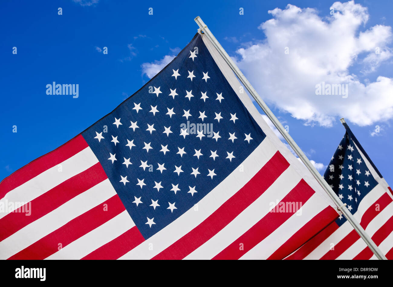 Primo piano di bandierine americane contro il cielo blu e nuvole bianche Foto Stock