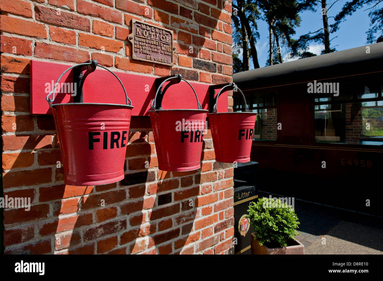 Fire bucket Pronto per l'uso alla stazione ferroviaria. Foto Stock