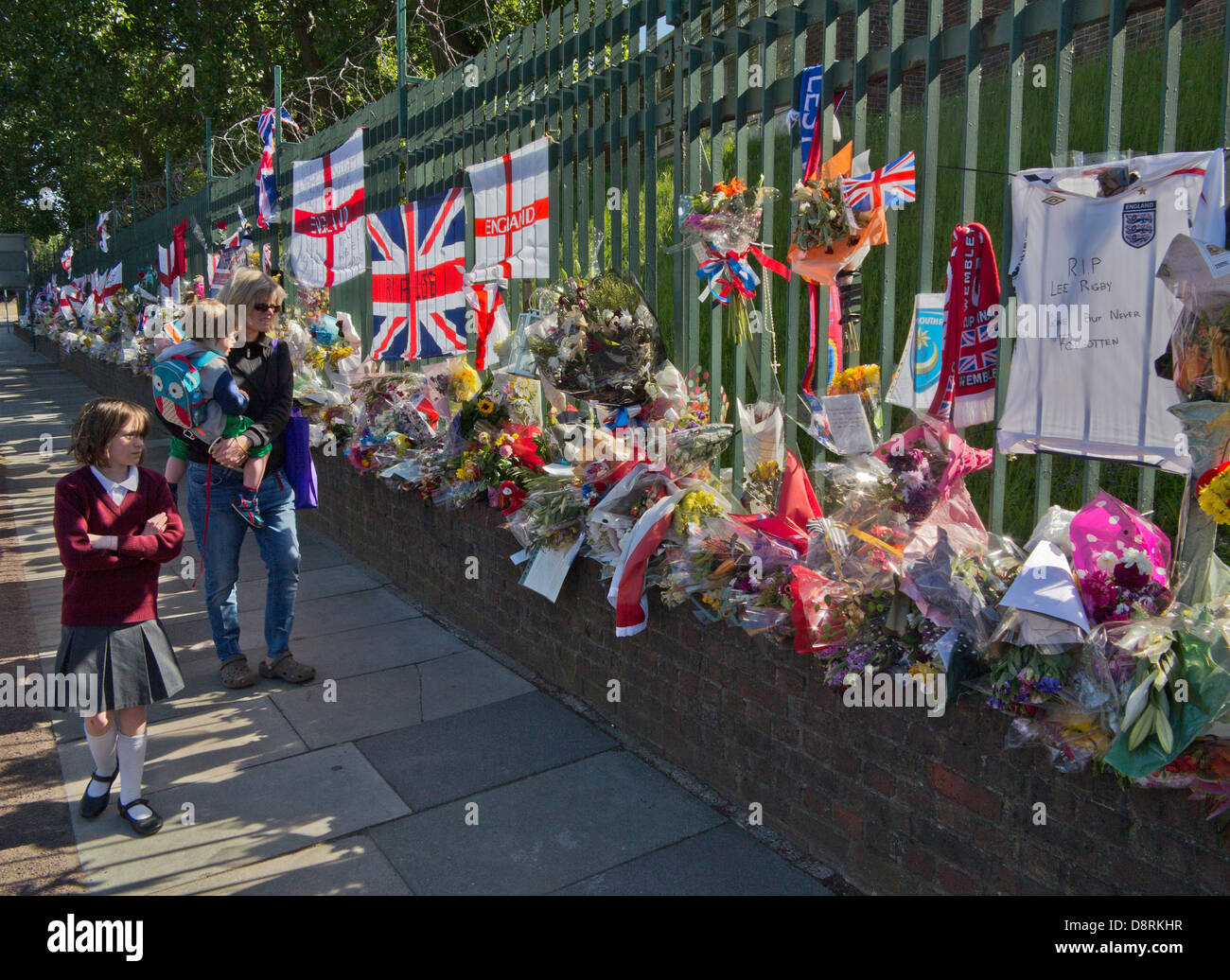 Madre e bambini a piedi passato omaggi floreali per il batterista Lee Rigby, uccisi fuori Woolwich Caserma a Londra il 22 maggio Foto Stock