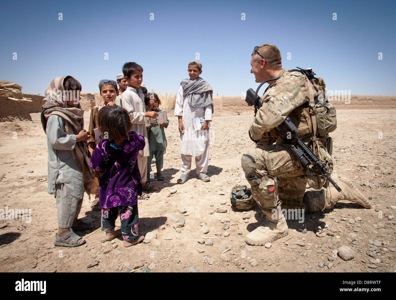 US Army Staff Sgt. Matteo Parsons con il consulente di polizia Team Delaram colloqui con bambini afgani Maggio 26, 2013 in Delaram, provincia di Helmand, Afghanistan. Foto Stock