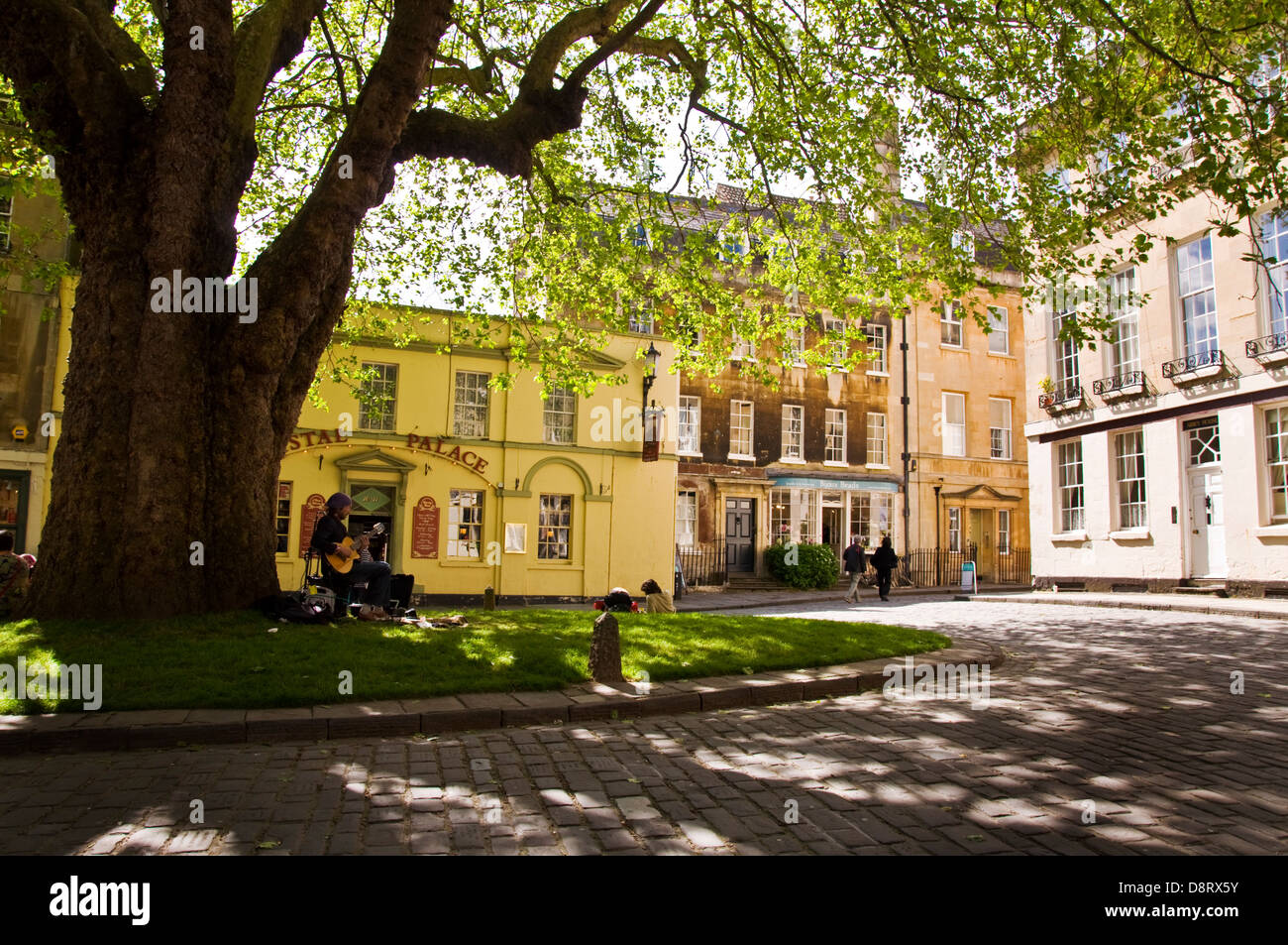 Un suonatore ambulante suona la chitarra su Abbey verde nel centro di Bath Foto Stock