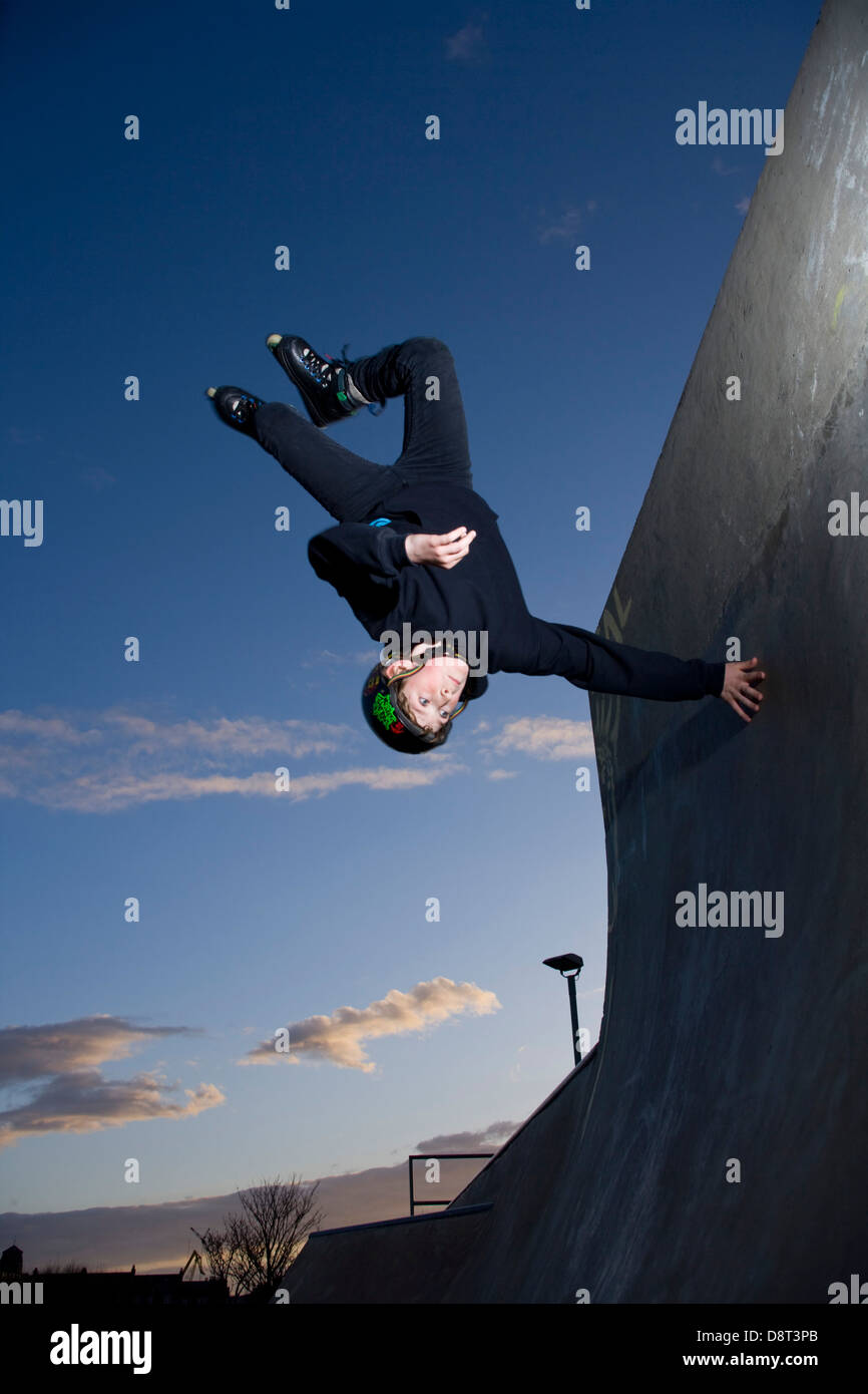 Il giovane skater capovolta in un Fife Skate Park. Foto Stock