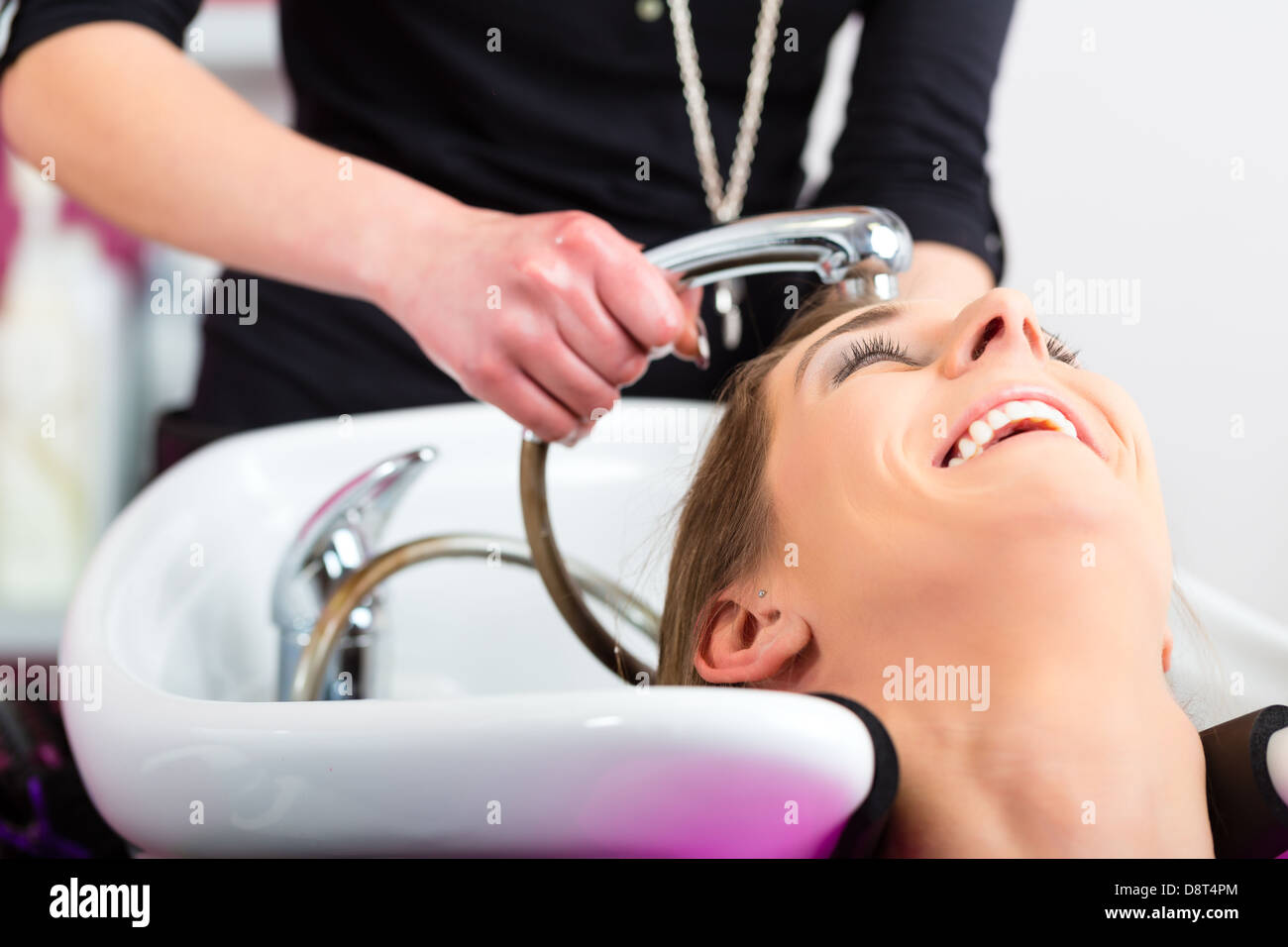 Donna al parrucchiere di ottenere i suoi capelli lavati e risciacquati sensazione visibilmente ben Foto Stock