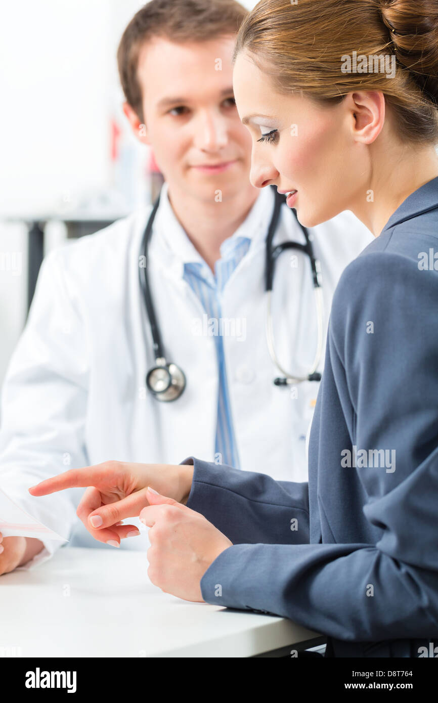 Giovane medico con il suo paziente in una consultazione per spiegare qualcosa Foto Stock