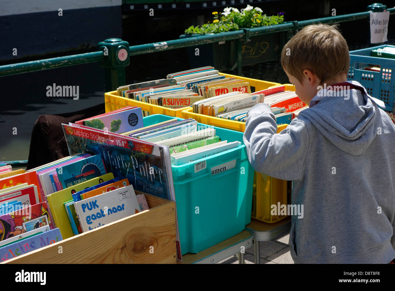 Ragazzo che guarda a seconda mano utilizzata fumetti a la Ajuinlei del mercato del libro a Gand, Belgio Foto Stock