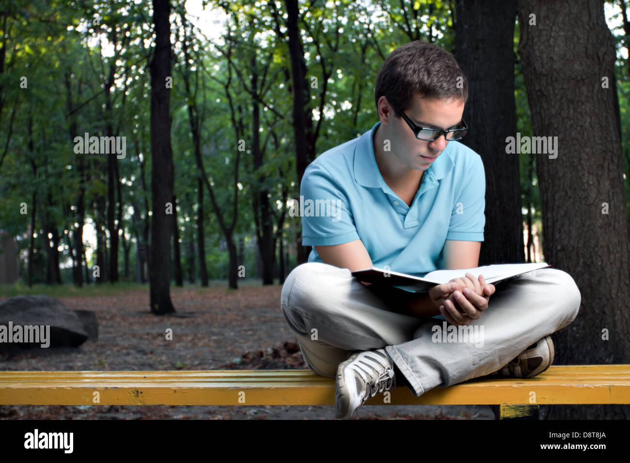 Giovane uomo libro di lettura nel parco Foto Stock