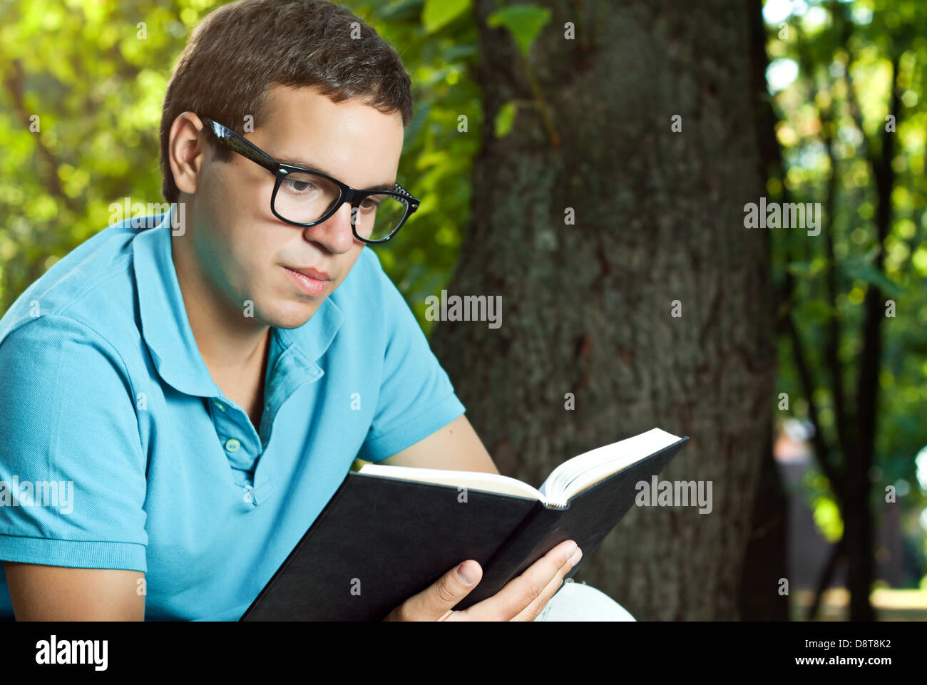 Giovane uomo libro di lettura nel parco Foto Stock