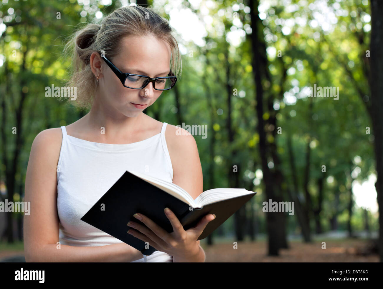 Giovane donna libro di lettura nel parco Foto Stock