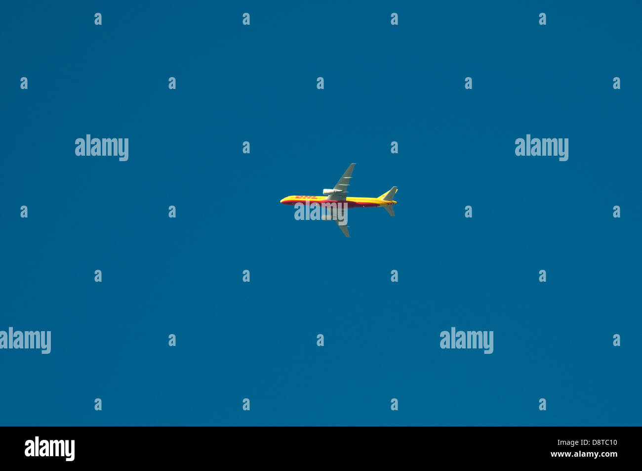 Un giallo e rosso Boeing 757-200 SF/PF azionato da DHL è visto contro un profondo cielo blu appena dopo che ha preso il largo da Malta Int Foto Stock
