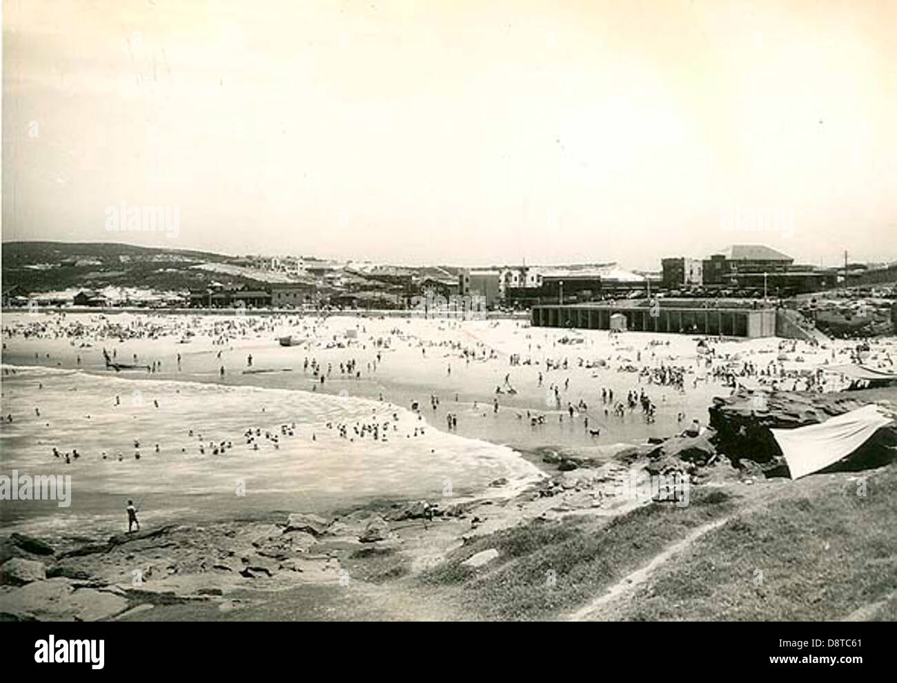 Questa fotografia in bianco e nero dagli archivi del New South Wales dello State Records cattura Maroubra Beach a Sydney, mostrando la vivace comunità della spiaggia con surfisti e nuotatori che si godono l'oceano. L'immagine risale a un'epoca precedente della cultura australiana delle spiagge. Foto Stock