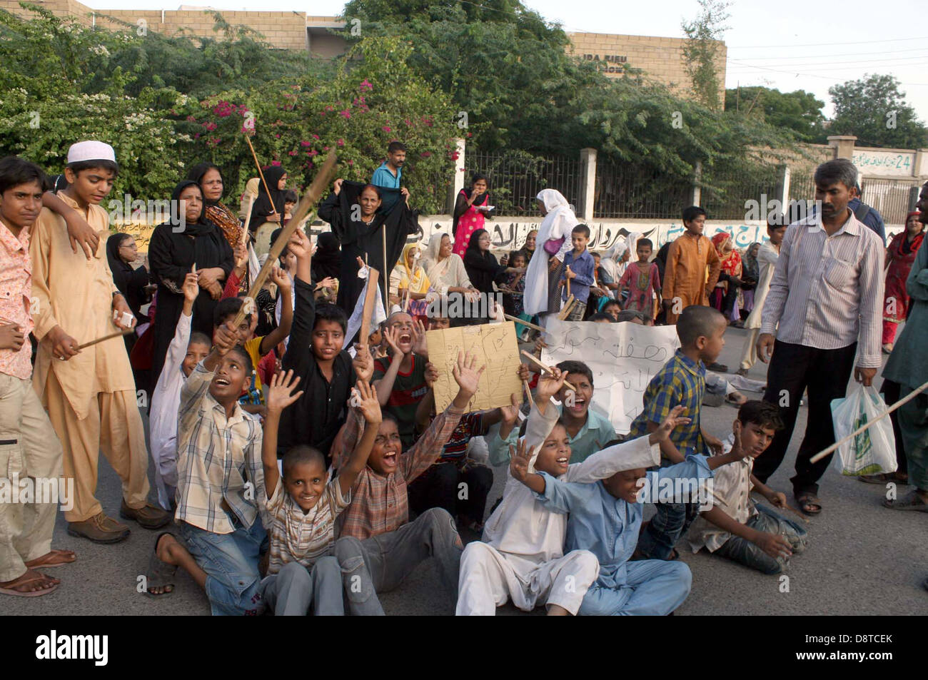 I residenti di linee protestano contro l'elettricità alleggerimento del carico e della carenza di acqua potabile nelle loro località durante una dimostrazione a M.A Jinnah Road a Karachi il Martedì, 04 giugno 2013. Foto Stock