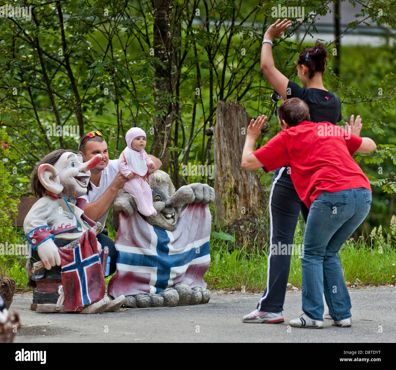Famiglia di scattare foto a un Norvegese troll statua, Steinsdalsfossen, Norvegia. Foto Stock