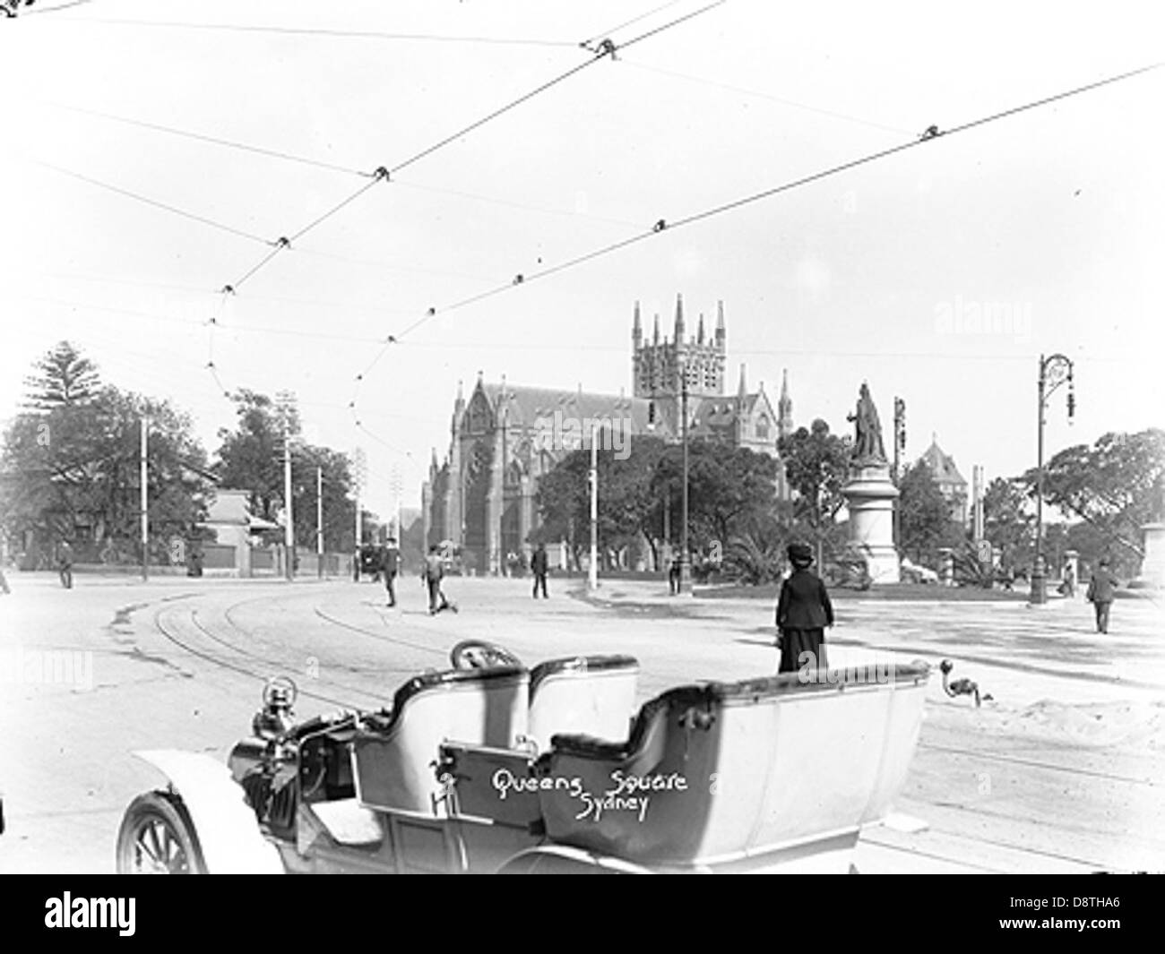 Una fotografia in bianco e nero del 1908 circa mostra Queen's Square a Sydney, con la Cattedrale di Santa Maria e una carrozza senza cavalli. L'immagine cattura un momento storico nello sviluppo e nei trasporti di Sydney. Foto Stock