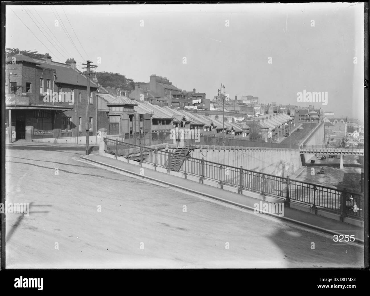 Questa fotografia in bianco e nero cattura il Munn Street Bridge e le case del personale del Sydney Harbour Trust, situato nello storico quartiere Rocks del New South Wales. L'immagine, conservata negli archivi della State Records NSW, mette in evidenza l'architettura e lo sviluppo urbano all'inizio del XX secolo. Foto Stock