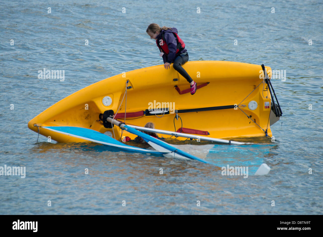 Ripristino da un improvviso capovolgimento nelle loro Laser vela dinghy sono questi due ragazzi godendo la loro giornata nel fiume Dart Foto Stock
