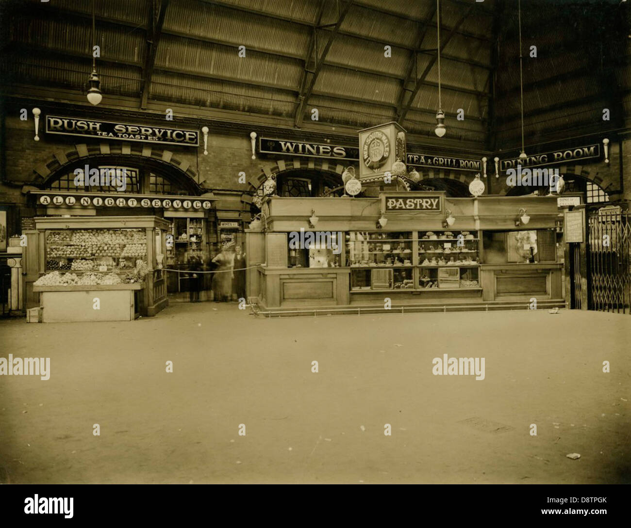 Questa fotografia in bianco e nero della stazione ferroviaria centrale di Sydney mostra frutta e pasticceria, che riflettono la vita quotidiana e il commercio in questo trafficato nodo dei trasporti. La foto offre un'istantanea di Sydney del XX secolo, catturando l'ambiente sociale e culturale della città. Foto Stock