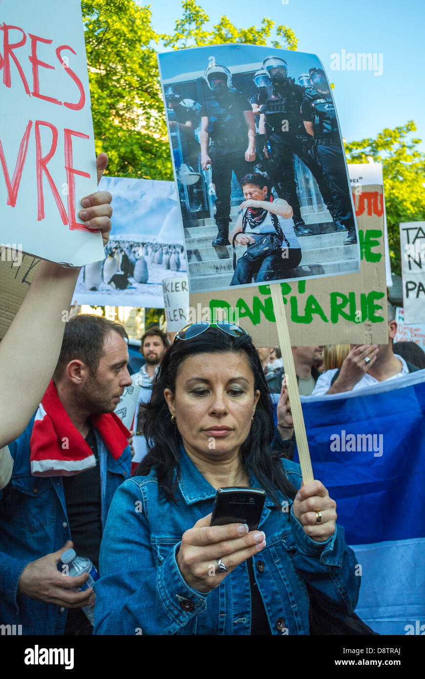 Parigi, Francia. Il popolo turco protesta contro la repressione del governo turco nelle recenti manifestazioni anti-governative An-kara. Donna con cartelli di protesta, SMS su smartphone, telefoni cellulari in francia, giovane donna in mezzo alla folla, dipendenza dagli smartphone Foto Stock