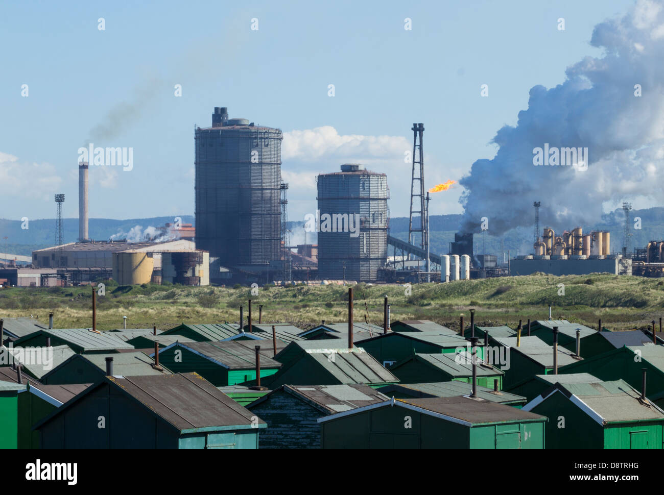 Vista su Fishermens capanne con Redcar acciaierie altoforno in background. A sud di gare, Redcar, England, Regno Unito Foto Stock