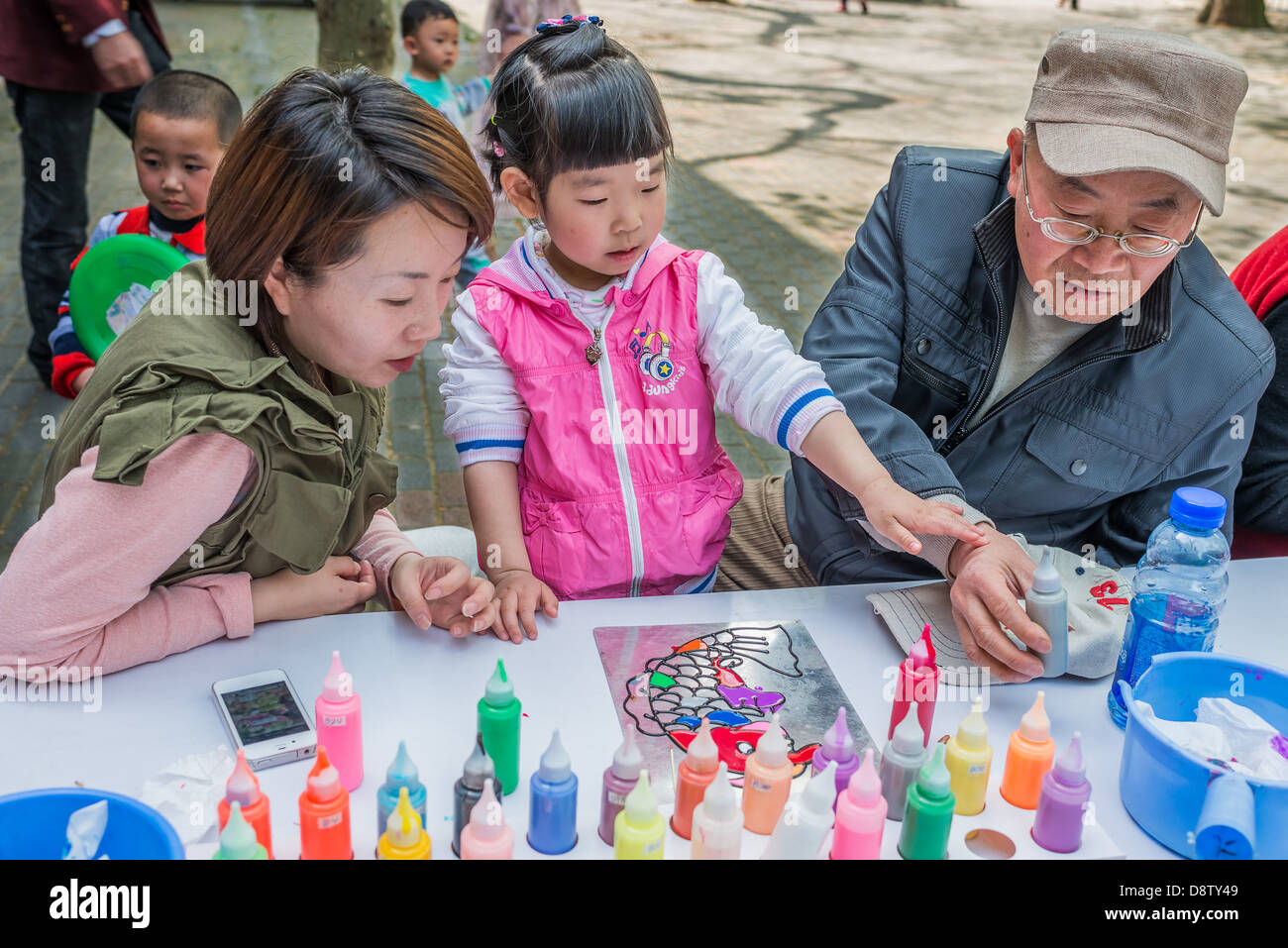 Shanghai, Cina - 7 Aprile 2013: tre generazioni la famiglia schizzi di piacere a Fuxing Park presso la città di Shanghai in Cina il 7 aprile 2013 Foto Stock