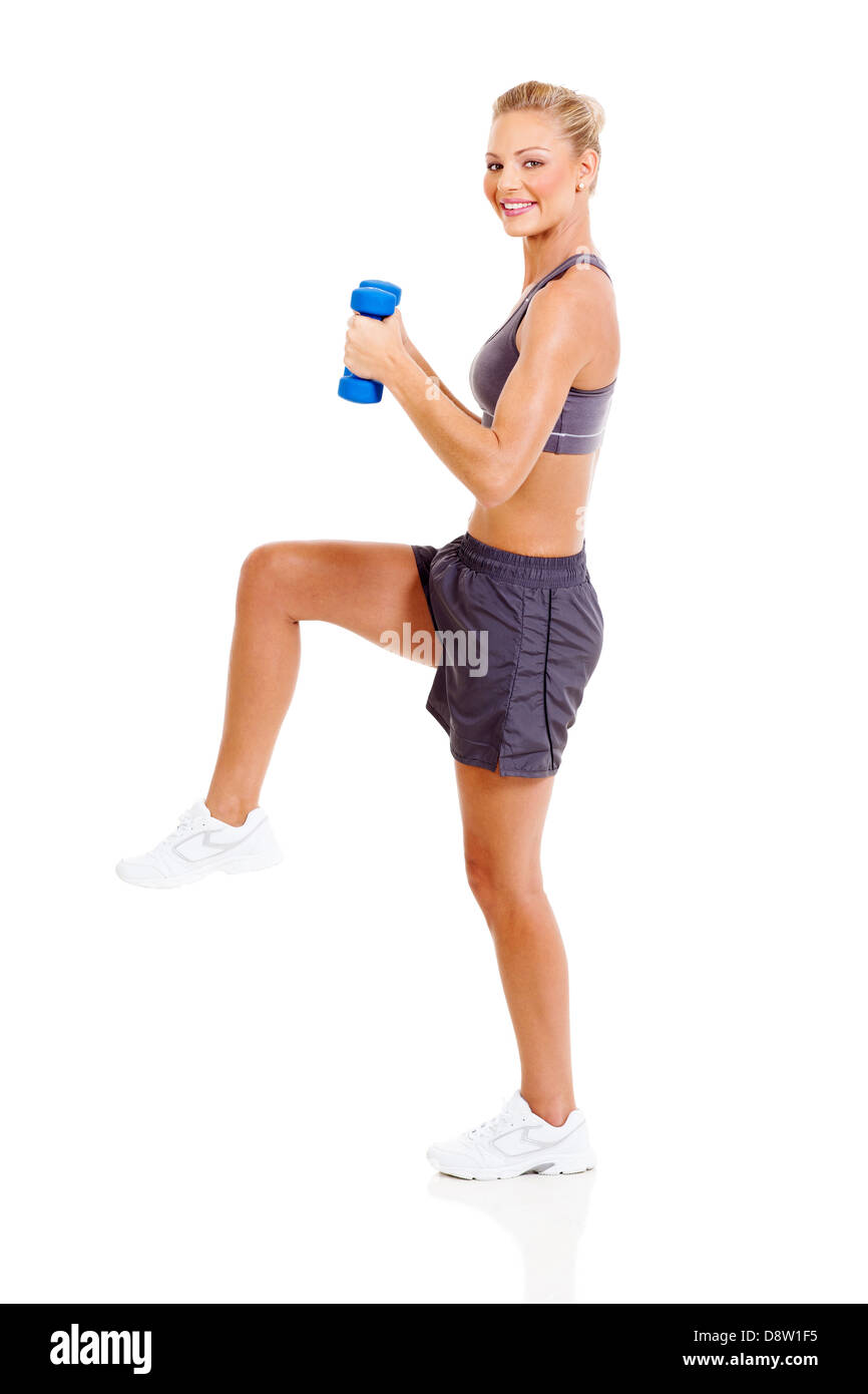 Montare donna esercizio con manubri con una gamba in alto Foto Stock