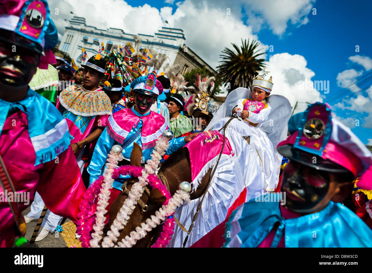 Un bambino ballerina passeggiate a cavallo nel corteo religioso all'interno del Corpus Christi festival in Pujilí, Ecuador. Foto Stock