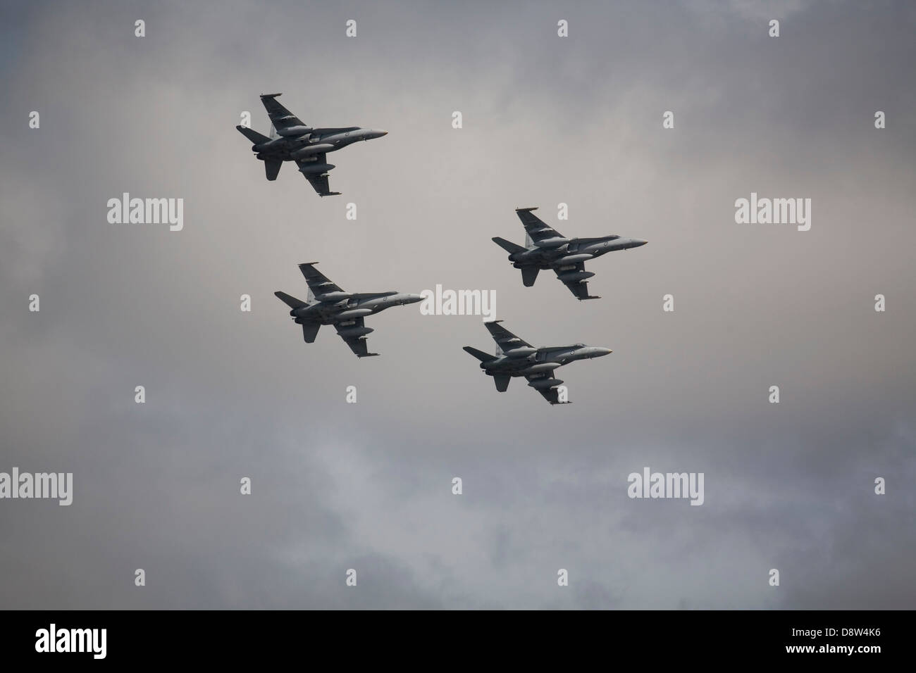 Quattro F/A-18 Hornet jet fighter aircraft del Royal Australian Airforce volare in formazione contro il cielo grigio Foto Stock