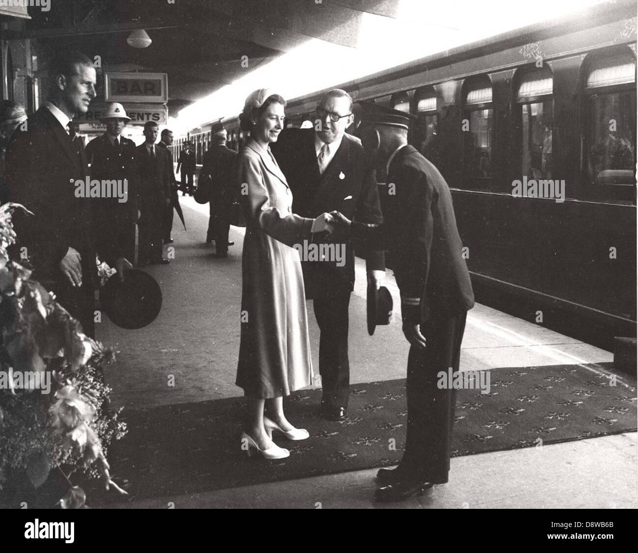 La regina Elisabetta II e il principe Filippo, accompagnati dal loro seguito, arrivano alla stazione ferroviaria di Bathurst, in Australia, durante la loro visita reale nel 1954, un evento nella storia australiana. Foto Stock