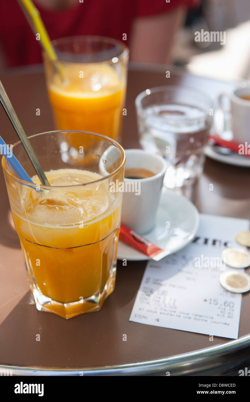 Succo di arancia,expresso e il disegno di legge su un tavolo in un bistrot Foto Stock