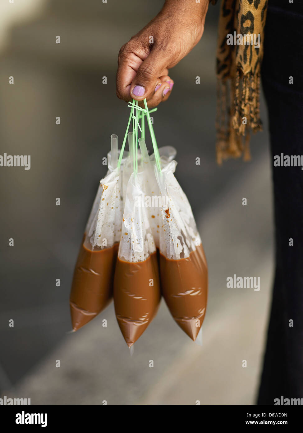 La donna che porta i sacchetti di plastica di caffè caldo Foto Stock