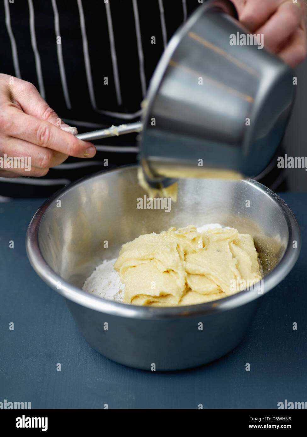 Versando la torta l'impasto in una ciotola di farina e sale Foto Stock