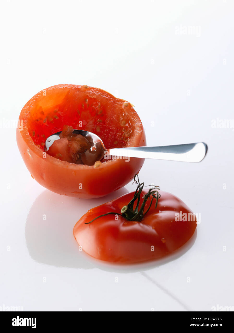 Tenendo la carne al di fuori di un pomodoro con un cucchiaio Foto Stock